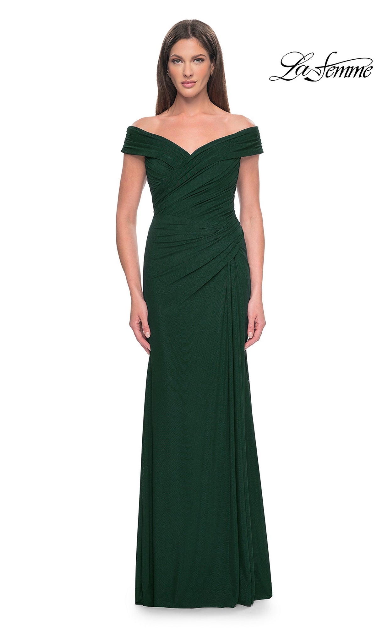 A woman models the La Femme Off-the-Shoulder Long Prom Dress 31677, a floor-length dark green gown with ruched detailing, against a white background. The